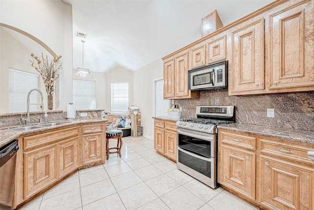 kitchen with tasteful backsplash, stainless steel appliances, sink, pendant lighting, and lofted ceiling