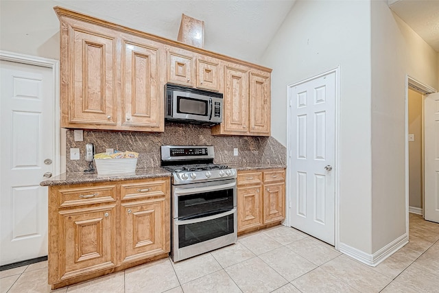 kitchen with tasteful backsplash, stone counters, light tile patterned flooring, and appliances with stainless steel finishes