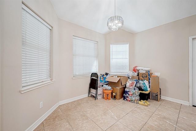 miscellaneous room featuring light tile patterned floors, vaulted ceiling, and a notable chandelier