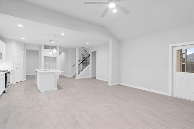 unfurnished living room featuring sink, ceiling fan, and light hardwood / wood-style flooring