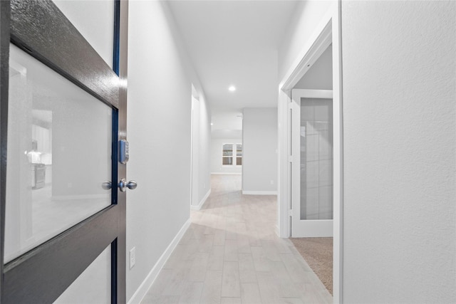 hallway with light hardwood / wood-style flooring