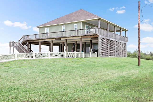 rear view of property featuring a deck and a lawn