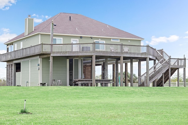 rear view of house featuring a wooden deck and a yard