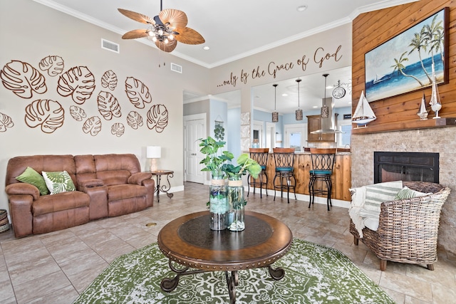 living room with ceiling fan, a fireplace, and ornamental molding