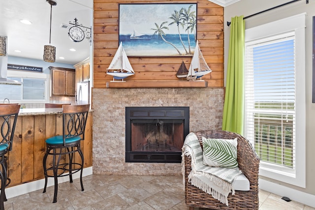 living area with crown molding and a tiled fireplace