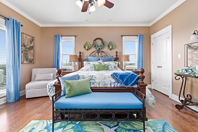 bedroom featuring ceiling fan, hardwood / wood-style flooring, and multiple windows