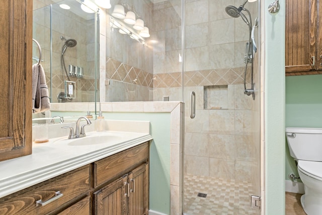 bathroom with a shower with door, vanity, and toilet