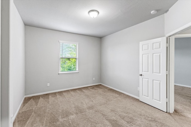 carpeted spare room with a textured ceiling