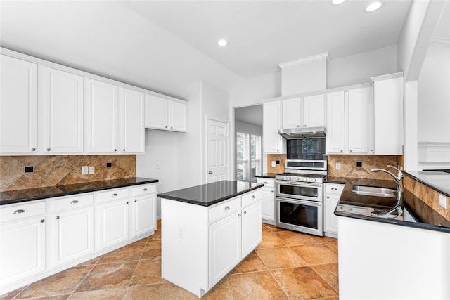 kitchen featuring sink, range with two ovens, and white cabinets