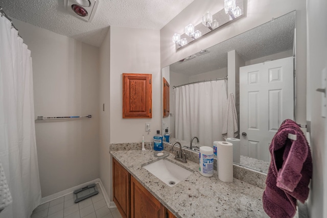 bathroom featuring vanity, a textured ceiling, and tile patterned floors