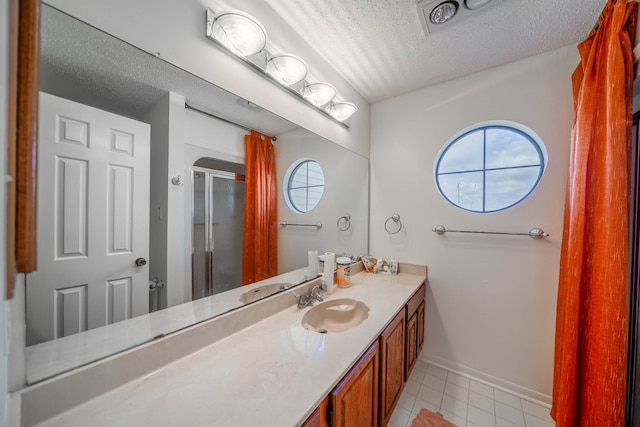 bathroom featuring vanity, a shower with shower door, and a textured ceiling