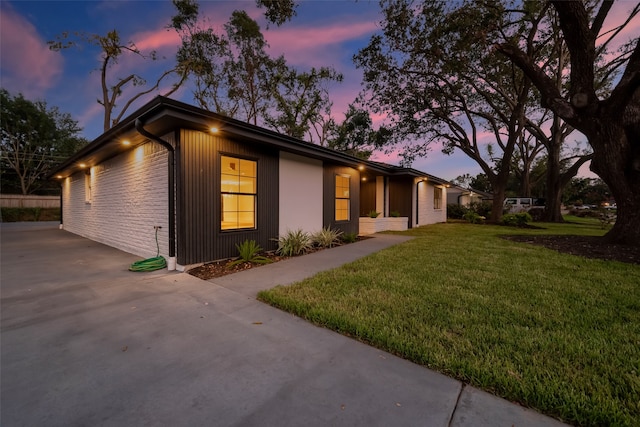 view of front of home with a patio and a lawn