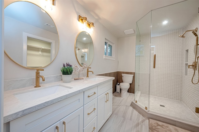 bathroom featuring toilet, wood walls, vanity, and a shower with door