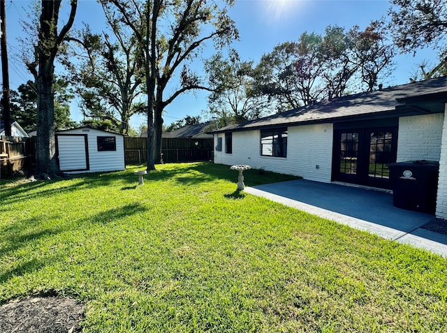 view of yard with a patio, french doors, and a storage shed