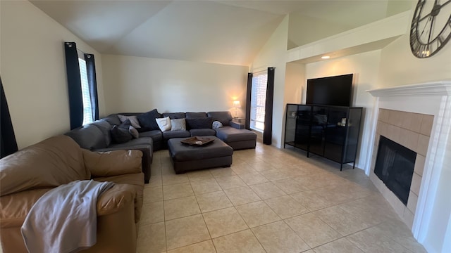 living room featuring a tile fireplace, light tile patterned floors, and lofted ceiling