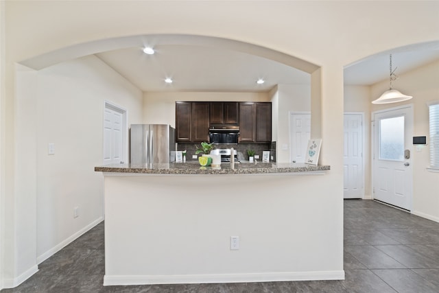 kitchen with light stone counters, dark brown cabinetry, decorative backsplash, pendant lighting, and appliances with stainless steel finishes