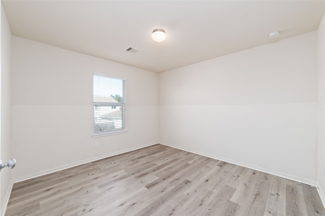 empty room featuring vaulted ceiling and light hardwood / wood-style flooring