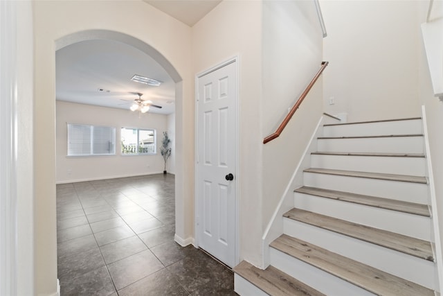 stairs with tile patterned floors and ceiling fan