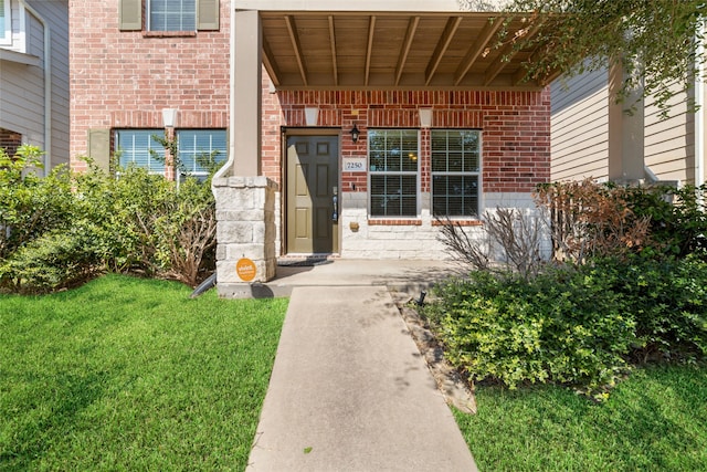 view of exterior entry featuring a yard