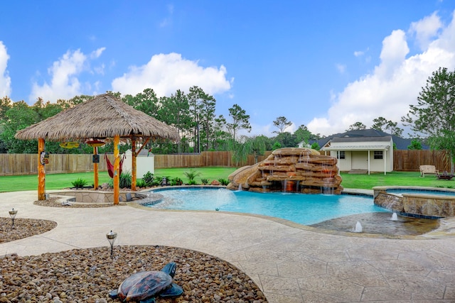 view of swimming pool with an in ground hot tub, pool water feature, a lawn, and a patio area