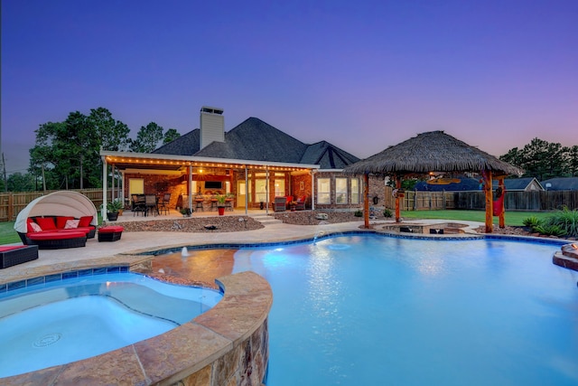 pool at dusk featuring an in ground hot tub, a gazebo, a patio, and outdoor lounge area