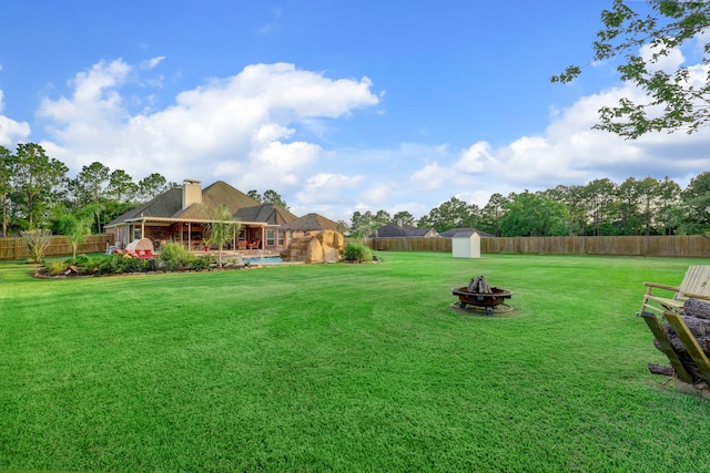 view of yard featuring an outdoor fire pit and a storage unit