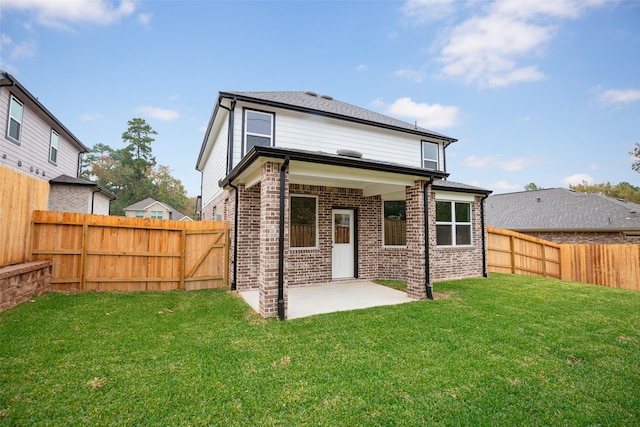 back of house featuring a lawn and a patio