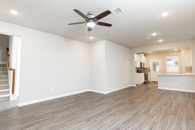 unfurnished living room featuring ceiling fan and light hardwood / wood-style flooring