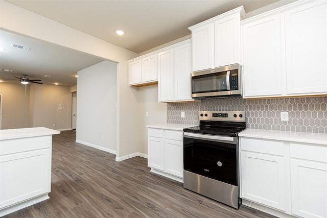 kitchen with white cabinetry, ceiling fan, stainless steel appliances, dark hardwood / wood-style floors, and backsplash