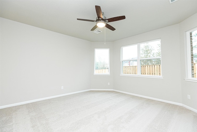 empty room featuring light carpet, plenty of natural light, and ceiling fan