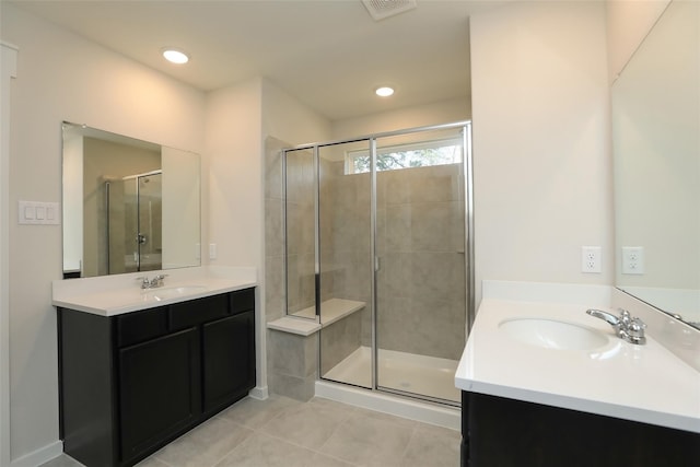 bathroom featuring tile patterned flooring, vanity, and a shower with shower door