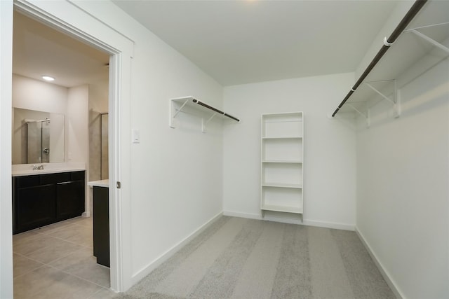 walk in closet featuring light colored carpet and sink