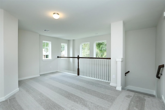 carpeted spare room featuring a healthy amount of sunlight