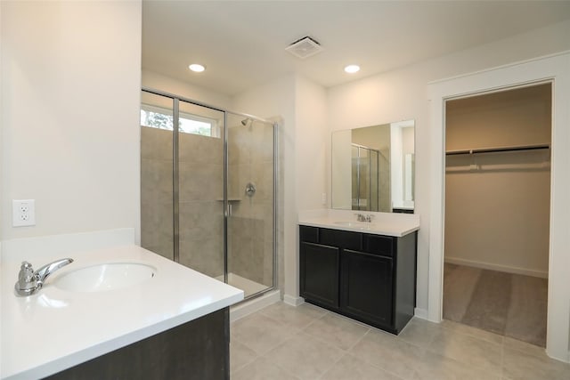 bathroom with tile patterned flooring, an enclosed shower, and vanity