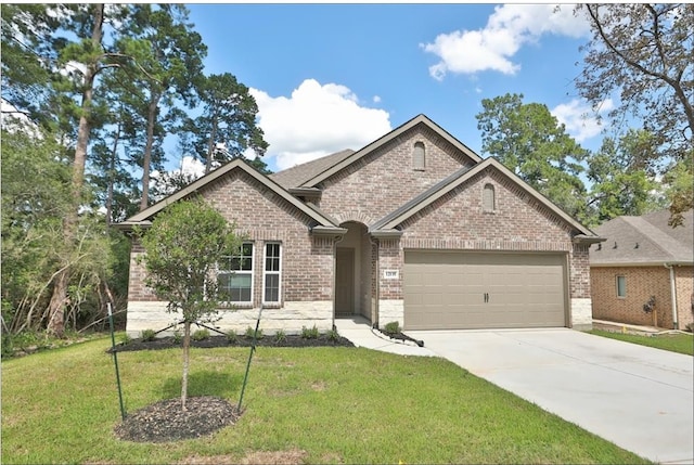 12135 Mustang Ave, Willis, TX 77378 - view of front of property featuring an attached garage, brick siding, concrete driveway, and a front yard
