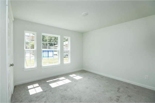 12135 Mustang Ave, Willis, TX 77378 - empty room featuring healthy amount of natural light, carpet, and baseboards