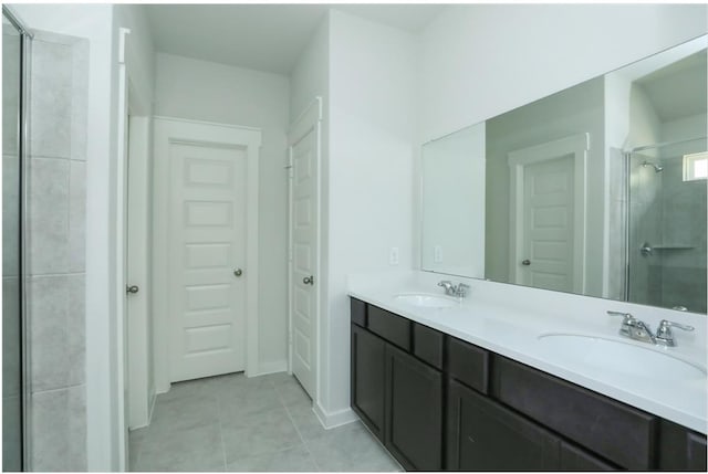 bathroom featuring tile patterned flooring, a shower with door, and vanity