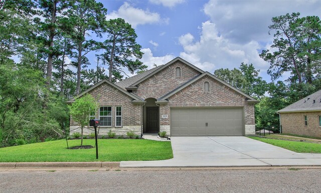 12135 Mustang Ave, Willis, TX 77378 - view of front of house featuring a garage, brick siding, driveway, and a front yard