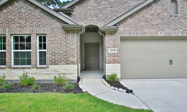 12135 Mustang Ave, Willis, TX 77378 - property entrance with a garage, brick siding, and concrete driveway
