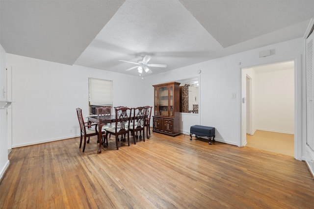 dining room featuring ceiling fan, a textured ceiling, and light wood-type flooring