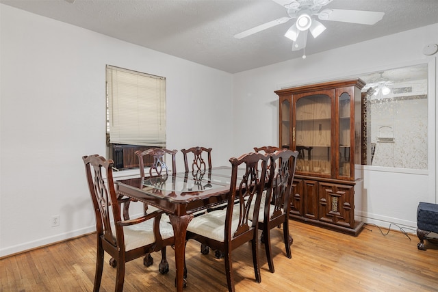 dining area with ceiling fan, a textured ceiling, and light hardwood / wood-style floors