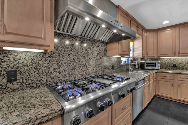 kitchen featuring light stone countertops, appliances with stainless steel finishes, tasteful backsplash, and wall chimney range hood