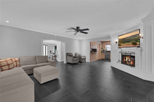 tiled living room with ceiling fan, ornamental molding, and a healthy amount of sunlight