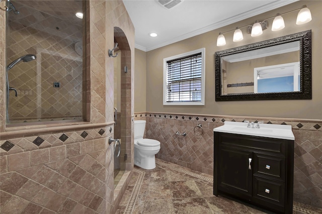 bathroom with vanity, tile walls, crown molding, and toilet