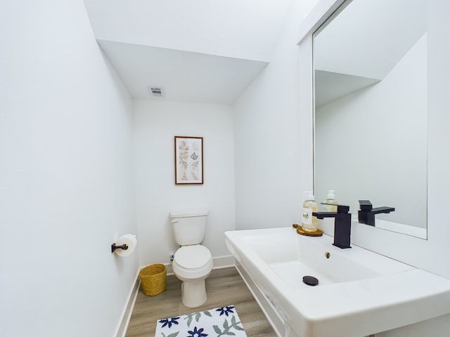 bathroom with hardwood / wood-style floors, sink, and toilet