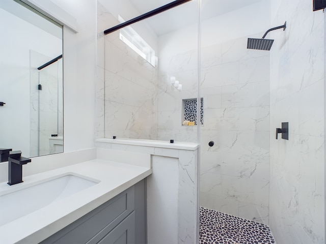 bathroom featuring a tile shower and vanity