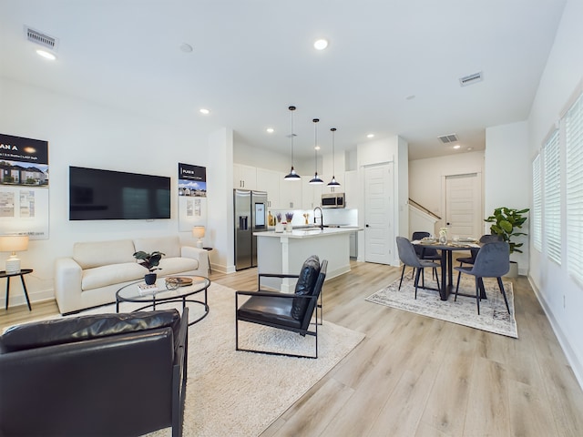 living room featuring light hardwood / wood-style flooring and sink