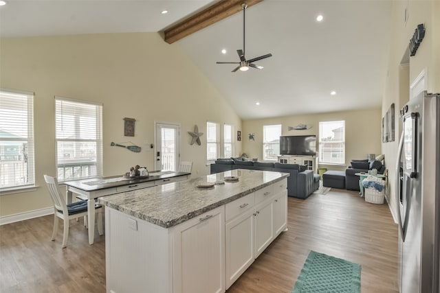 kitchen featuring high vaulted ceiling, stainless steel refrigerator, white cabinetry, and light hardwood / wood-style flooring