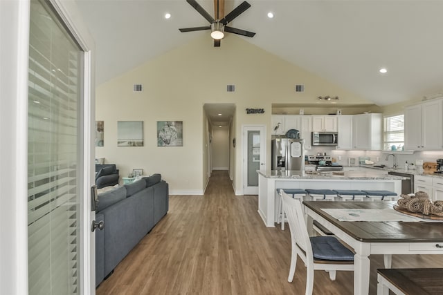 kitchen featuring stainless steel appliances, light wood-type flooring, sink, and white cabinetry