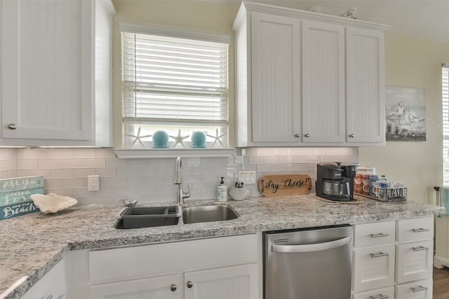 kitchen featuring decorative backsplash, sink, stainless steel dishwasher, and white cabinetry